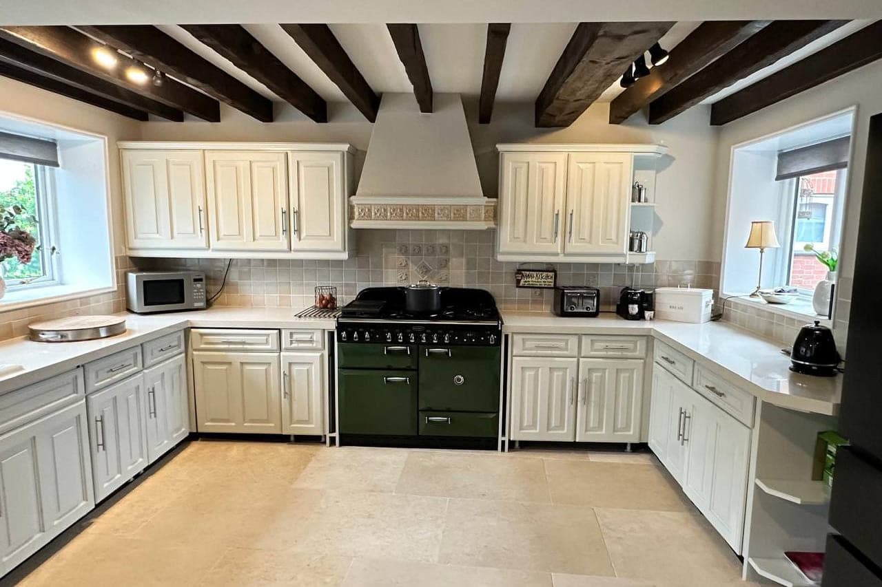 Hand painted kitchen units and cornice in a room with exposed beams