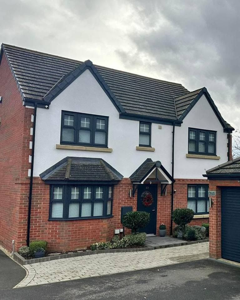 A full house elevation sprayed in anthracite grey: windows, front door, fascias, soffits and the garage door